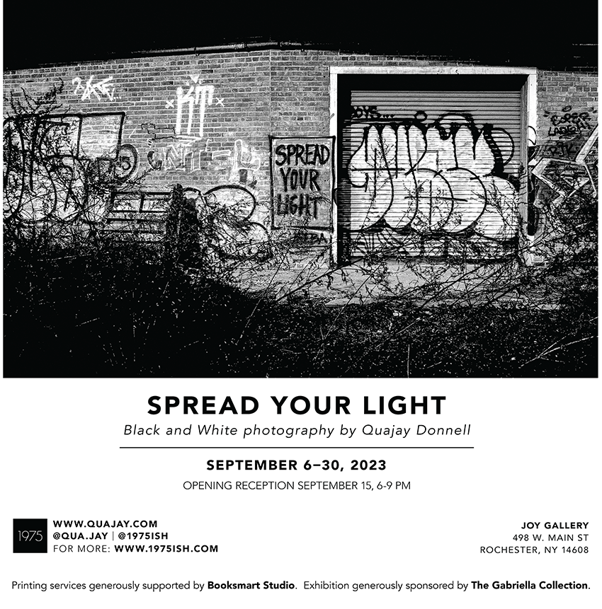 black and white image of a wall with graffiti featuring the phrase Spead Your Light
